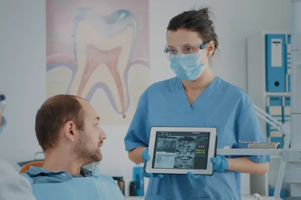 A dentist showing a patient an x-ray